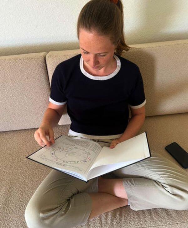 Junge Frau liest in ihrem Geburtshoroskop als Buch